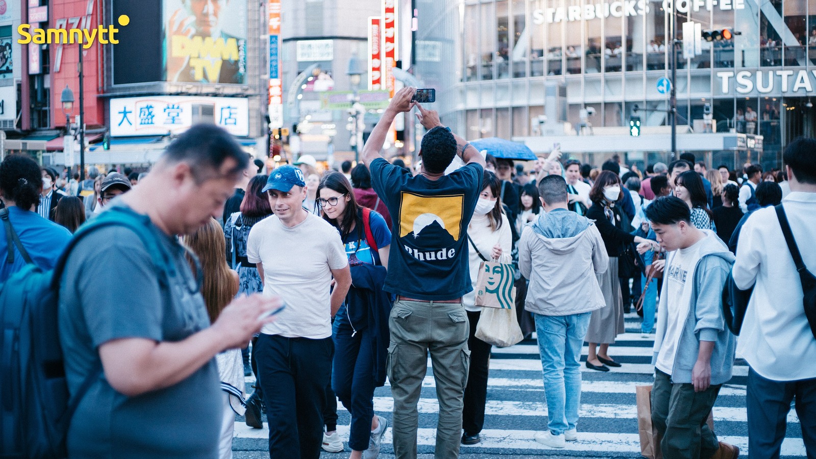 Folkmassa korsar övergångsstället i Shibuya-korsningen i Tokyo